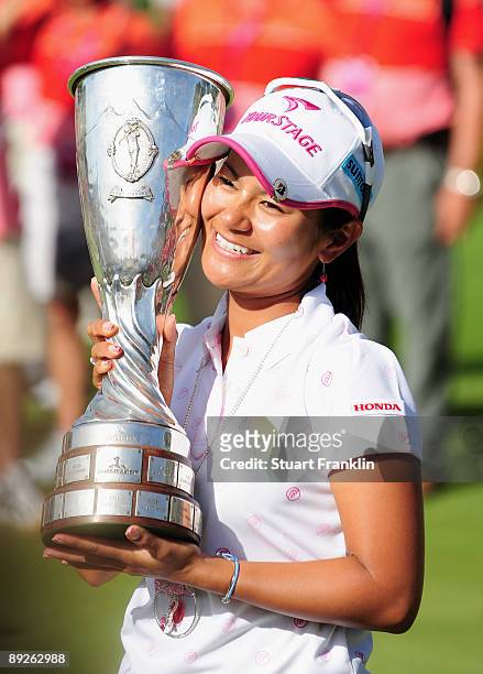 Ai Miyazato of Japan poses with the winners trophy after winning in a playoff against Sofie Gustafson of Sweden after the final round of the Evian...