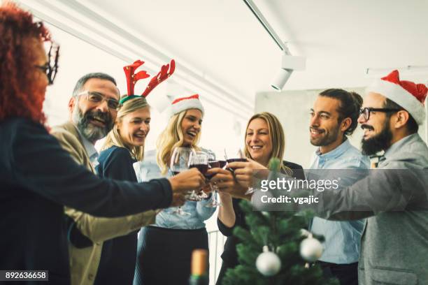 business people toasting with red wine at workplace - christmas party office stock pictures, royalty-free photos & images