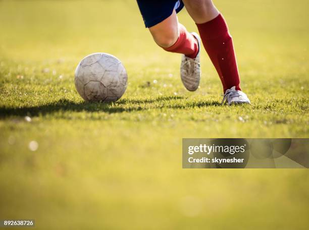 jogador de futebol irreconhecível correr com uma bola. - atacar termo esportivo - fotografias e filmes do acervo