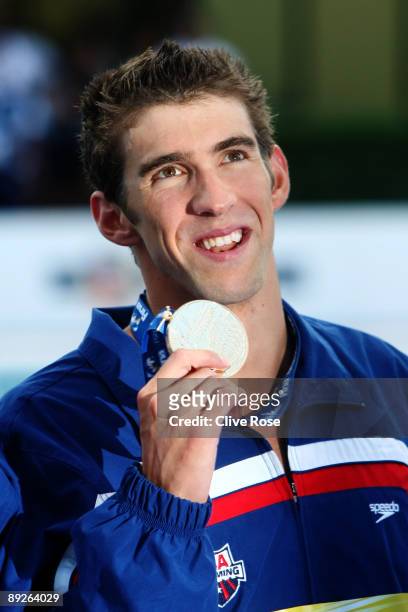 Michael Phelps of the United States celebrates as he receives the gold medal during the medal ceremony for the Men's 4x 100m Freestyle Final during...