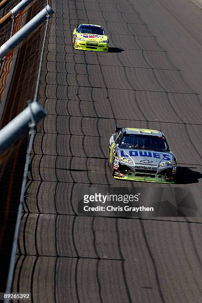 Jimmie Johnson, driver of the Lowe's/KOBALT Tools Chevrolet, drives in front of Mark Martin, driver of the CARQUEST/Kellogg's Chevrolet, before...