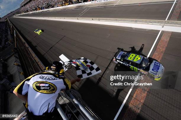 Jimmie Johnson, driver of the Lowe's/KOBALT Tools Chevrolet, crosses the finish line to win the NASCAR Sprint Cup Series Allstate 400 at the...