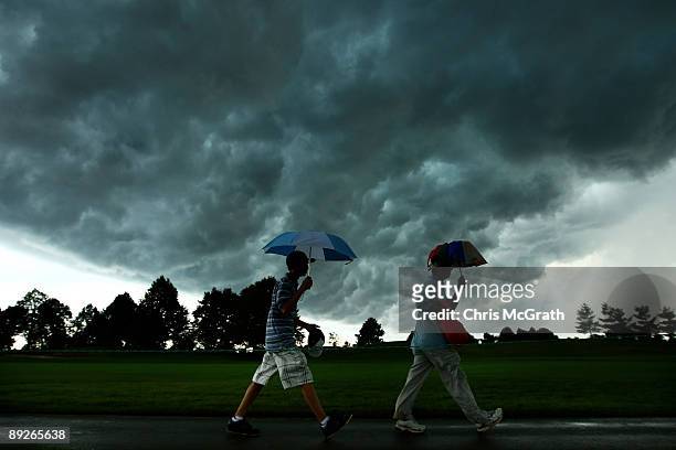 Spectators leave the golf course after play was cancelled for the day due to an extreme thunderstorm during round three of the RBC Canadian Open at...