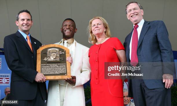 Inductee Rickey Henderson accepts his plaque from National Baseball Hall of Fame President Jeff Idelson, Hall of Fame chairman Jane Forbes Clark, and...