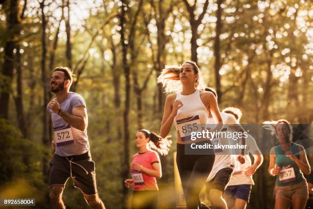 grote groep gemotiveerde lopers een marathon lopen in de natuur. - 10000 meter stockfoto's en -beelden