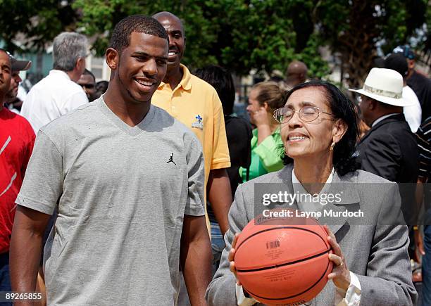 Chris Paul of the New Orleans Hornets watches Mary June Willard shoot a basket before dedicating the Hardin Playground basketball court, painted to...