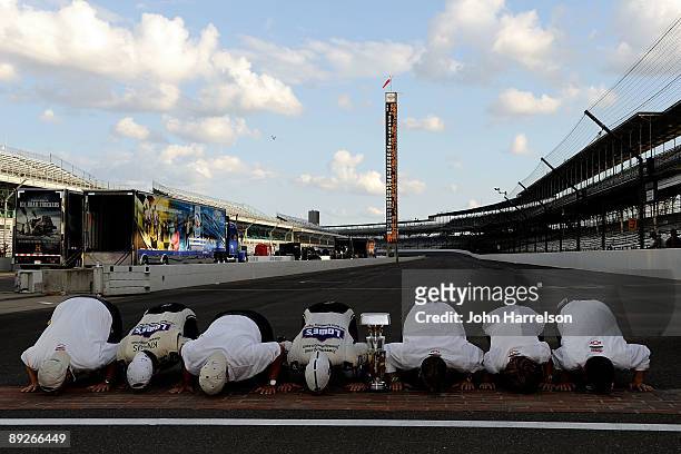 Jimmie Johnson, driver of the Lowe's/KOBALT Tools Chevrolet, celebrates by kissing the bricks with his team after Johnson wins the NASCAR Sprint Cup...