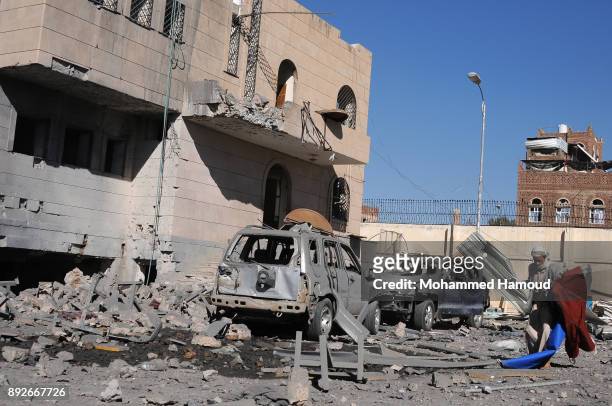 Man walks near cars destroyed outside a prison after it was hit by airstrikes on December 13, 2017 in Sana’a, Yemen. More than 12 prisoners killed...