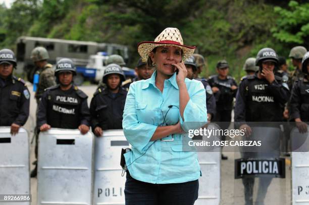 Xiomara Castro de Zelaya, wife of ousted president of Honduras Manuel Zelaya, speaks in her mobile phone in a military road blockade near the town of...