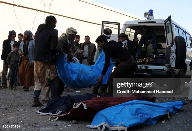 People carry a body of a prisoner after he was killed in airstrikes targeted the prison on December 13, 2017 in Sana’a, Yemen. More than 12 prisoners...