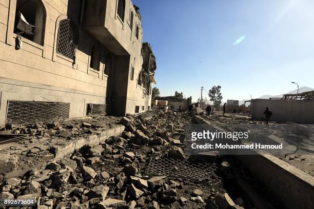 People walk on rubble of a prison after it was hit by airstrikes on December 13, 2017 in Sana’a, Yemen. More than 12 prisoners killed and 80 others...