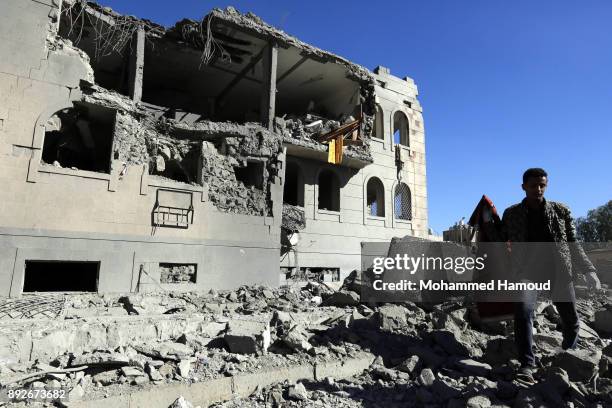 People walk on rubble of a prison after it was hit by airstrikes on December 13, 2017 in Sana’a, Yemen. More than 12 prisoners killed and 80 others...