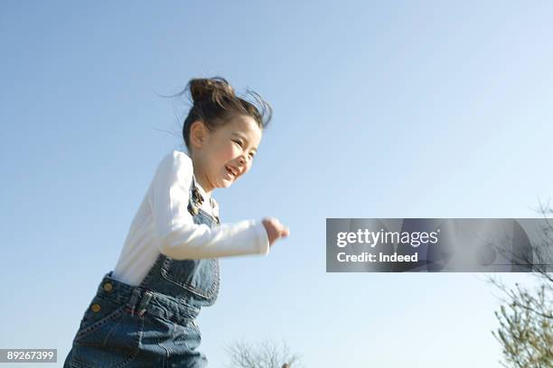 girl (8-9) running, smiling - only kids at sky stock pictures, royalty-free photos & images