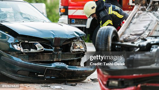 Feuerwehrleute bei einem Auto-Unfall-Szene Feuerwehrleute bei einem Auto-Unfall-Szene