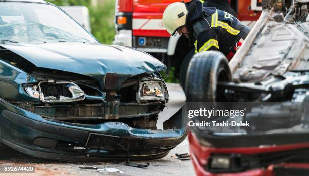 firefighters at a car accident scene - inicdent stock pictures, royalty-free photos & images