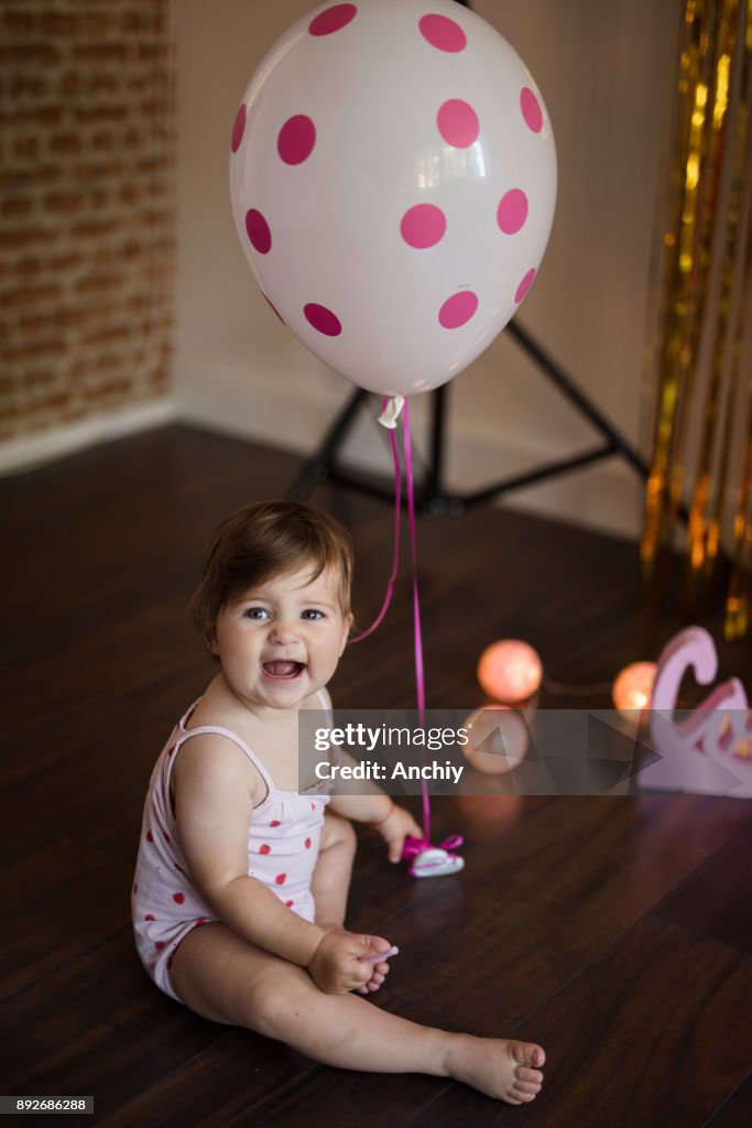 Happy cute little baby girl playing with ballon