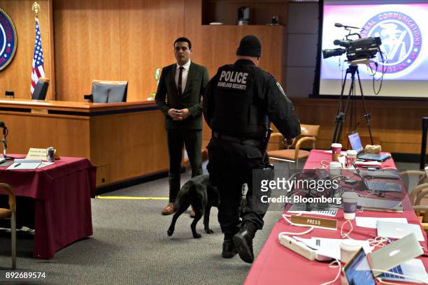 Police officer walks a bomb detection dog through the Federal Communications Commission meeting room during an evacuation at an open commission...