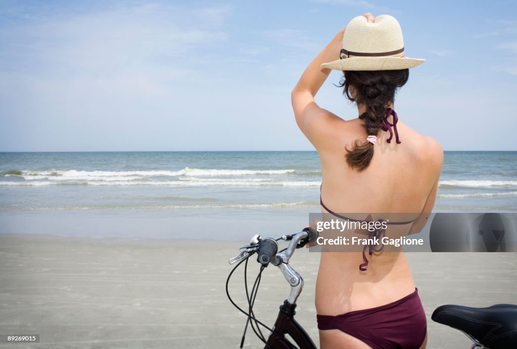 Woman Stopping on Bike to Enjoy Ocean View.