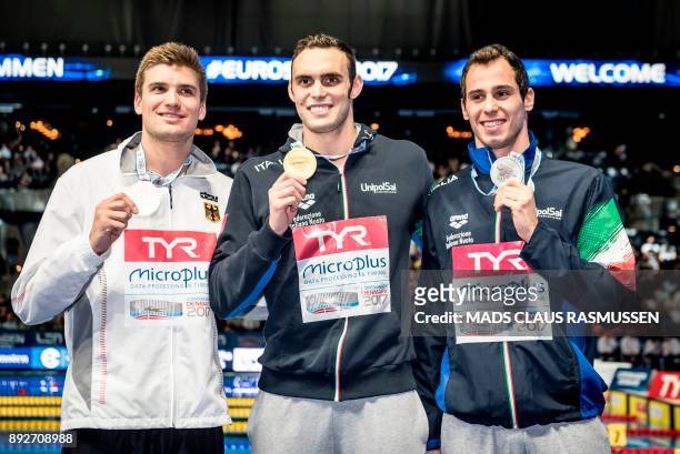 Third placed Marius Kusch from Germany, winner Matteo Rivolta from Italy and second placed Piero Code from Italy pose after the 100 meter butterfly...