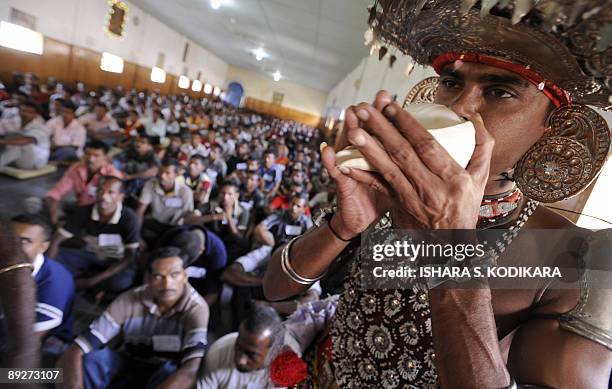 Sri Lankan traditional Kandyan dancer blows his conch shell during a religious ceremony to release military deserters from a prison in Colombo on...