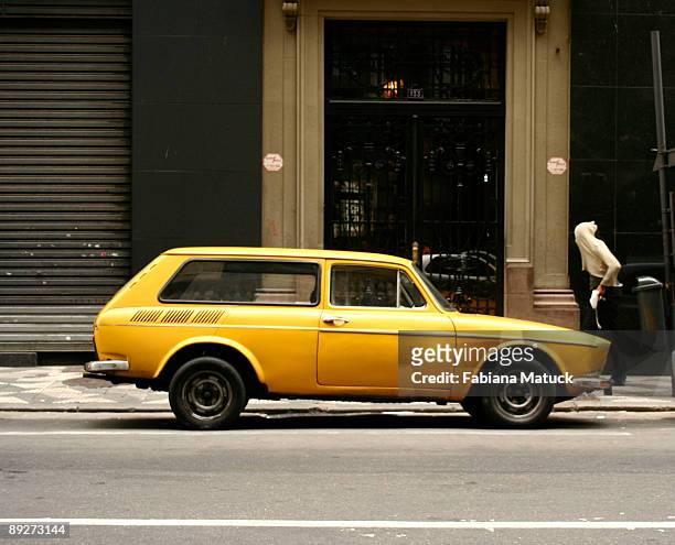 covered face beggar and the yellow car - ancine and car stock pictures, royalty-free photos & images