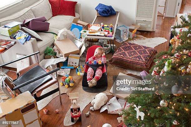 young boy surrounded by opened gifts on christmas - disordinato foto e immagini stock