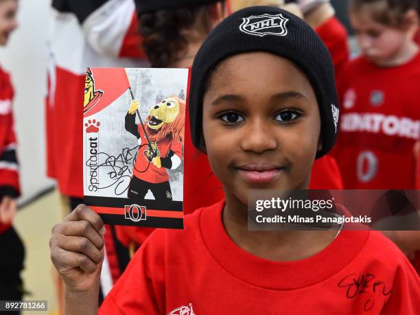 Youngster shows off a signed Spartacat card during the 2017 Scotiabank NHL100 Classic Legacy Project press conference at the Boys & Girls Club -...