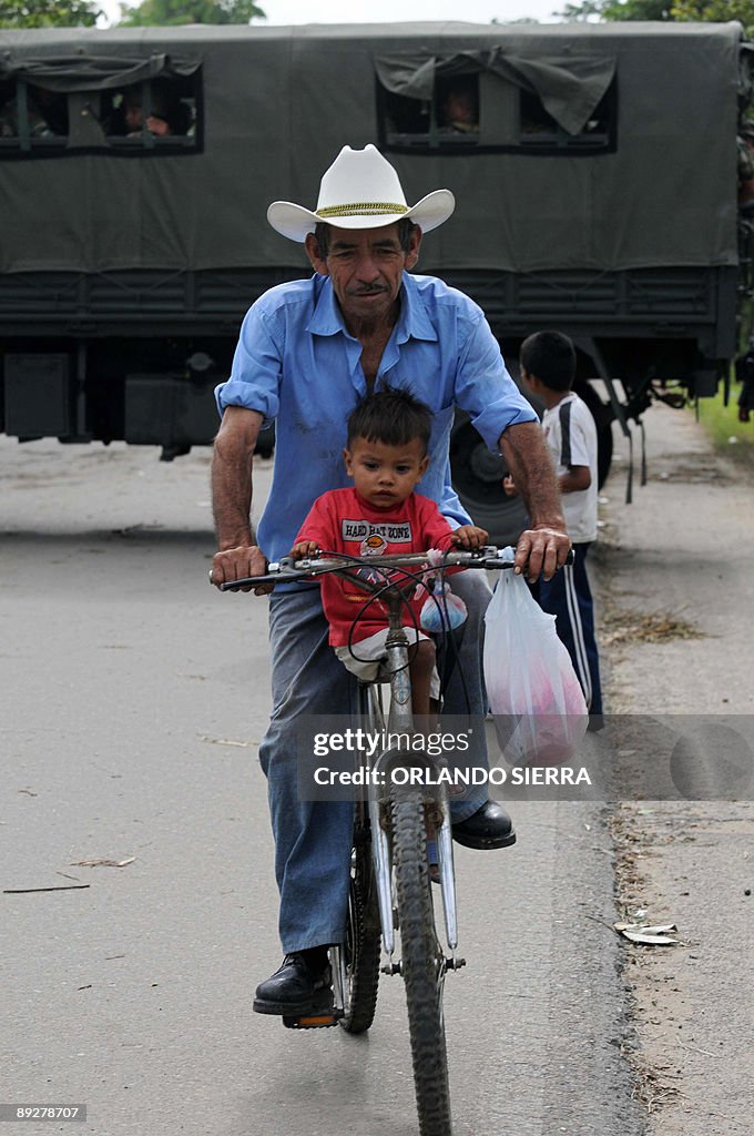 A man carries a boy in his bike near a c