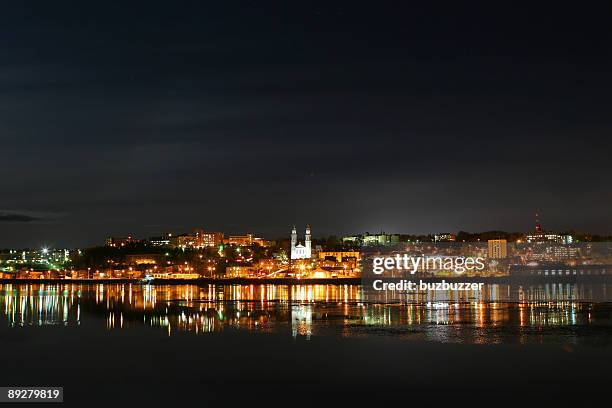 nightime scene of chicoutimi city reflection over the saguenay river - buzbuzzer stock pictures, royalty-free photos & images