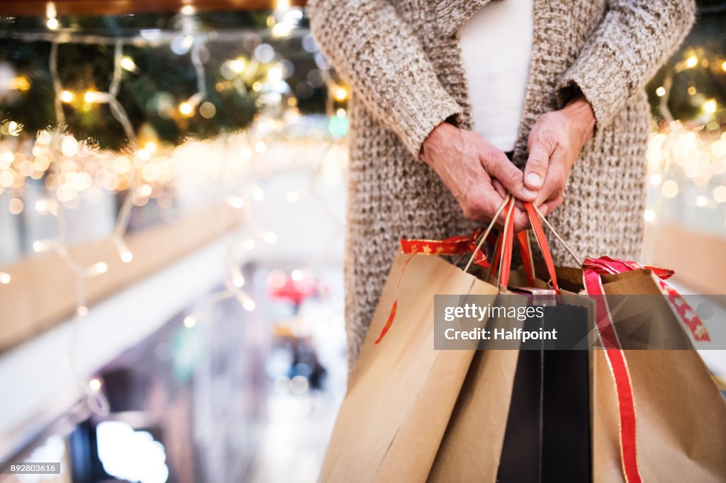 Mujer Senior con bolsas de hacer compras de Navidad.