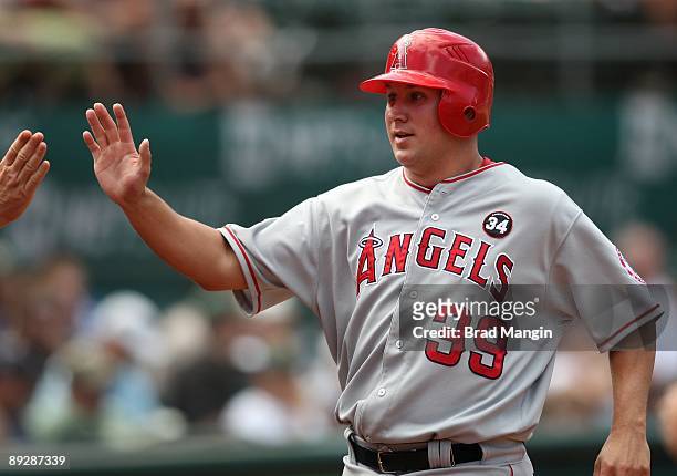 Robb Quinlan of the Los Angeles Angels of Anaheim celebrates with his teammates against the Oakland Athletics during the game at the Oakland-Alameda...