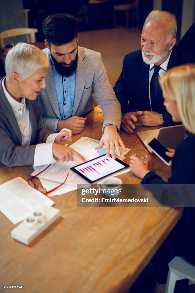 Blandad ålder business-team med ett möte i café.