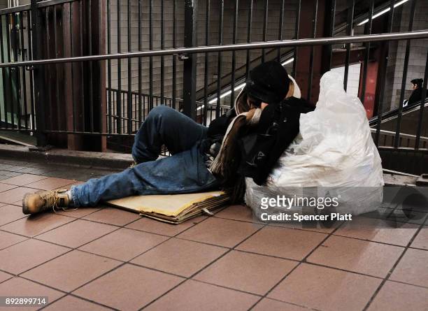 Man sleeps on the ground at a Manhattan train station on December 14, 2017 in New York City. According to a new report released by the U.S....