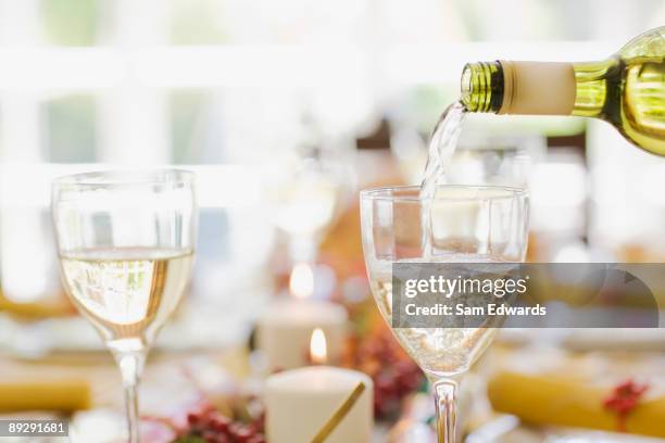 white wine being poured into glass on table - white wine glass bildbanksfoton och bilder