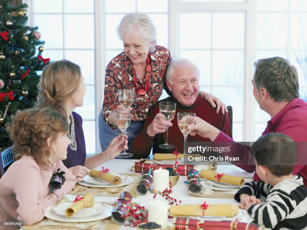 Multi-generation family toasting at Christmas dinner