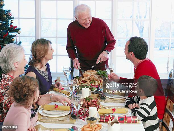 man carving christmas turkey at table - carving craft product stock pictures, royalty-free photos & images