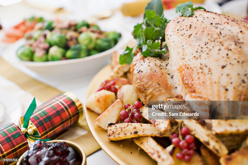 Turkey, cranberries and Christmas cracker on table