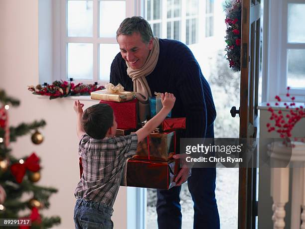 少年はパパクリスマスのギフトを持つ - child giving gift ストックフォトと画像