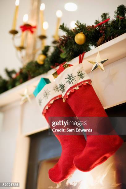 christmas stockings hanging on fireplace mantel - kousen stockfoto's en -beelden