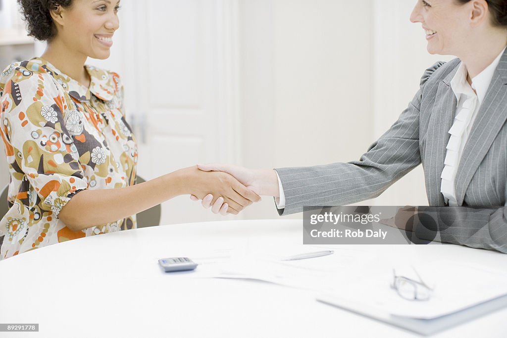 Real estate agent and woman shaking hands