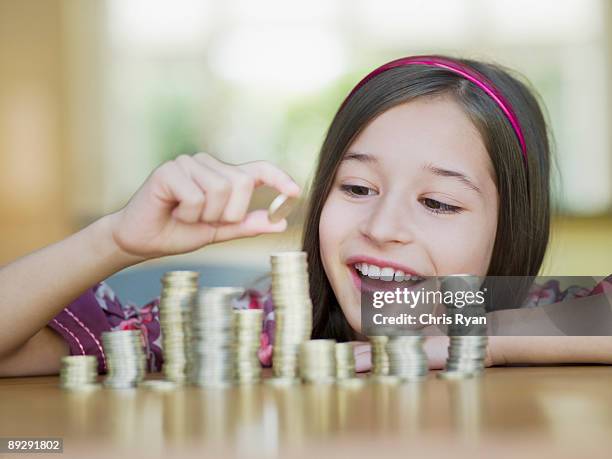 chica monedas de apilado - kids money fotografías e imágenes de stock