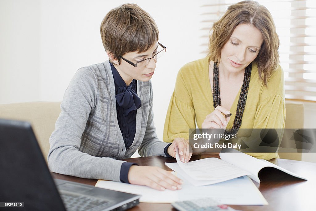 Businesswoman reviewing paperwork with woman