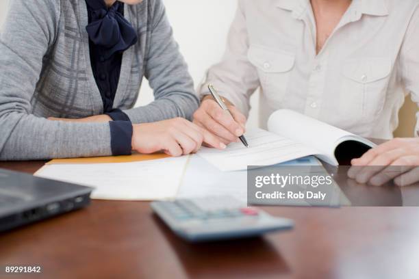 donna d'affari firma di documenti - consulenza fiscale foto e immagini stock