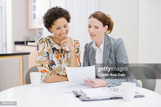 businesswoman reviewing paperwork with woman - truth be told 個照片及圖片檔