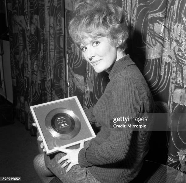 Petula Clark gets a golden disc for 'Downtown', her record which sold a million copies, 1st March 1965.