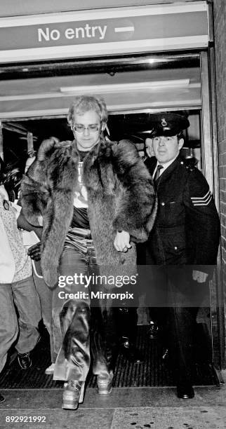 Elton John arrives at Heathrow Airport, and has to run from the crowds of fans who are waiting there. It is not clear if Elton is flying in, or...