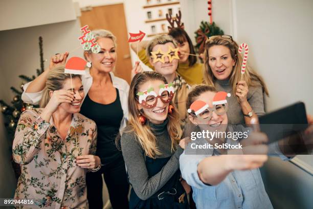 compañeros de trabajo tomando selfie - office christmas party fotografías e imágenes de stock