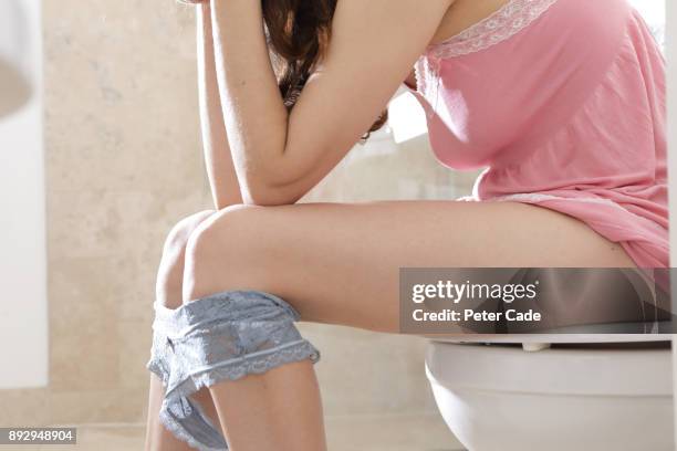 woman sat on toilet - bragas fotografías e imágenes de stock