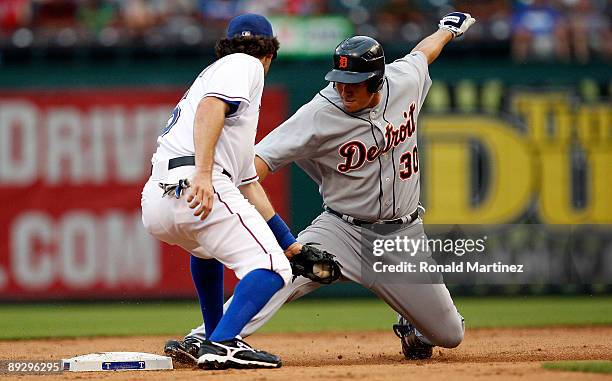 Right fielder Magglio Ordonez of the Detroit Tigers beats the tag for a double against Ian Kinsler of the Texas Rangers on July 27, 2009 at Rangers...