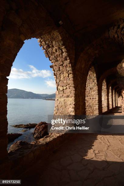 arches and public path under chateau de la napoule mandelieu-la-napoule - darmschleimhaut stock-fotos und bilder